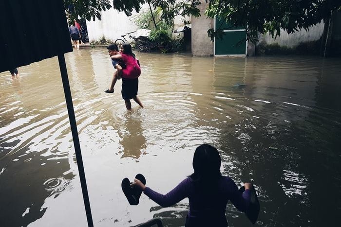 Một ông bố cõng con đi tìm quán ăn. Ảnh: Lê Thắng