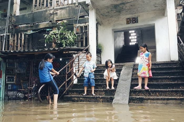 Lũ trẻ được nghỉ học tỏ vẻ thích thú khi nước dâng ngập sân. Ảnh: Lê Thắng