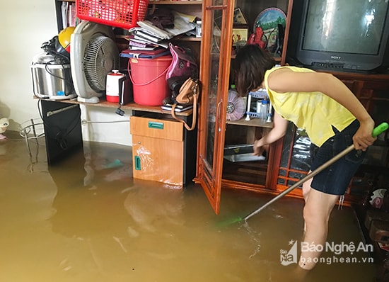 Nước đã vào nhà các hộ dân ở tầng 1. Trong ảnh: Người dân tranh thủ cọ rửa vật dụng trong nhà. Ảnh: Phú Hương