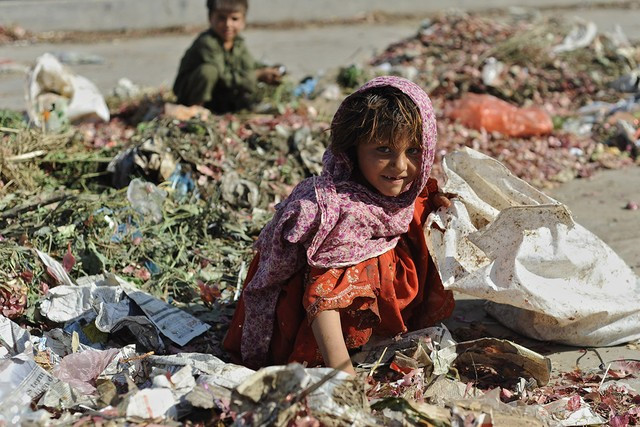 Đói  nghèo luôn rình rập trẻ em gái trên thế giới. Trong ảnh: Một em gái đang tìm kiếm đồ ăn trong bãi rác ở Islamabad, Pakistan.
