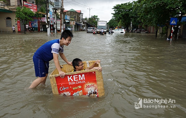 Nhiều tuyến phố lớn biến thành ‘sông’ chỉ sau một đêm mưa. Trái với nỗi lo toan của người lớn, nhiều đứa trẻ lại sung sướng khi được nghỉ học ở nhà, được co ra trên giường nhìn nước lên, được lội nước bắt cá tràn lên sân… Ảnh: Thành Cường