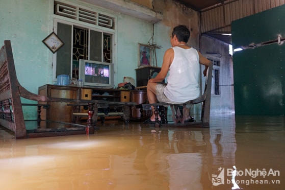 Những hàng xóm gần nhà anh cũng chịu hoàn cảnh tương tự. Đến 17h, nước mới chỉ rút nhẹ không đáng kể. Ảnh: Thành Cường.