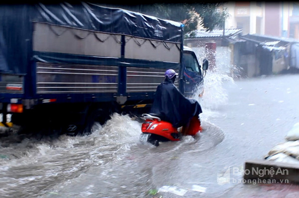 Con đường phía sau chợ Vinh ngập nặng, các phương tiện bì bõm lội nước sau trận mưa vào sáng nay (13/10). Ảnh : Q.A