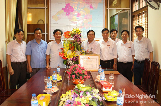 Lãnh đạo huyện tặng hoa chúc mừng Ngân hàng nông nghiệp và phát triển huyện Quỳnh Lưu. Ảnh: Thanh Toàn