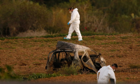 Các chuyên gia pháp y đang thu thập chứng cứ tại hiện trường vụ đánh bom xe sát hại nữ nhà báo điều tra của Malta - Ảnh: REUTERS