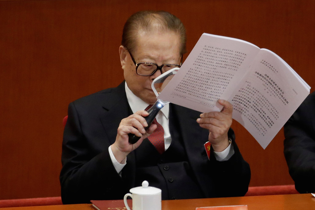 Cựu tổng bí thư Giang Trạch Dân chăm chú đọc toàn văn bài phát biểu của Tổng bí thư Tập Cận Bình. Ảnh: Reuters.
