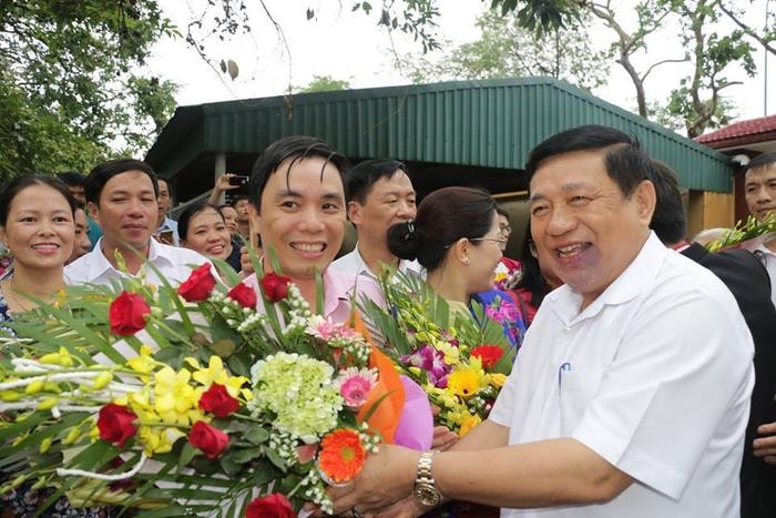 Chủ tịch UBND tỉnh Nguyễn Xuân Đường tặng hoa cho thầy giáo Trần Văn Nga sau khi có hai học sinh đạt Huy chương Vàng và Bạc tại Kỳ thi Olympic Vật lý Quốc tế năm 2017. Ảnh: Mỹ Hà