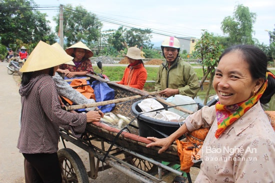 Những “kẻ quê” sau một đêm chài lưới, mang theo cả thuyền thúng đến bán cá trước cổng chợ. Ảnh: Huy Thư