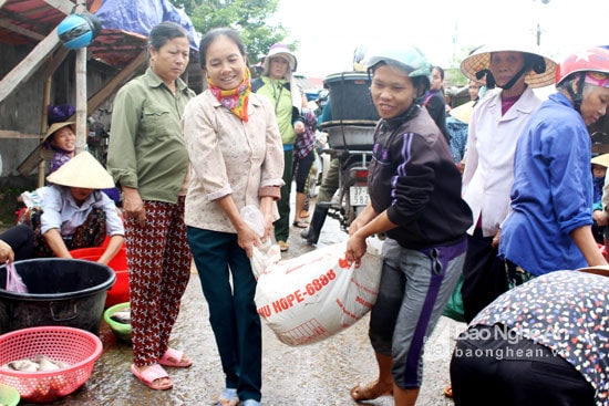 Những người dân vạn chài khiêng cả bì cá tươi sống vừa đánh được trên sông đến chợ. Chị Bùi Thị Phương quê xã Nam Thái (Nam Đàn) – một “kẻ quê” thường xuyên bán cá ở chợ Cồn cho biết: Những ngày mưa lũ, nhà chị đánh bắt được hàng tạ cá mỗi đêm, kiếm được bạc triệu, sau đó thì cá giảm dần theo nước lũ. Ảnh: Huy T hư