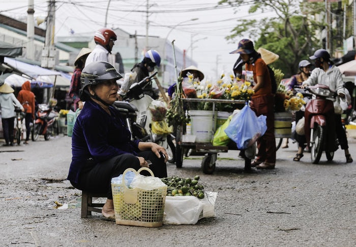 Những người phụ nữ đang mưu sinh ở chợ Vinh đối với họ những xe hoa, gánh hàng bán được nhiều hơn, kiếm nhiều tiền hơn trang trải cho gia đình lại là niềm vui của họ. Ảnh Đức Anh