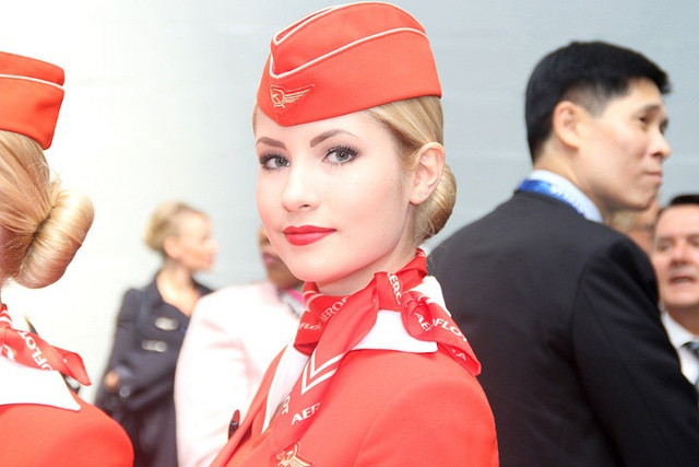 Cận cảnh một nữ chiêu đãi viên xinh xắn của hãng bay dân dụng Aeroflot. Sắc đỏ và logo “búa liềm có cánh” là những nét đặc trưng của hãng này. Ảnh: Flickr.