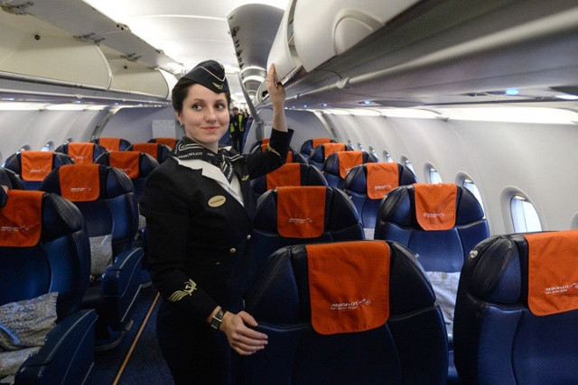 Một nữ tiếp viên Aeroflot trong trang phục màu tối nhưng vẫn gắn logo búa liềm, xuất hiện trong khoang máy bay của hãng này. Ảnh: Sputnik.