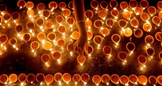 Một người sùng kính chiếu đèn dầu vào buổi lễ tôn giáo trong lễ hội Diwali, hay Deepavali, tại một ngôi đền Hindu ở Colombo, Sri Lanka ngày 18 tháng 10 năm 2017.