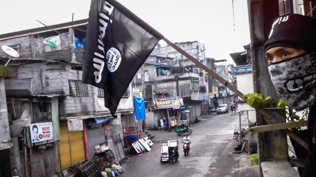 Lá cờ đen – ‘biểu tượng’ của IS cùng một phiến quân tại một ngôi nhà ở thành phố Marawi hồi tháng Năm. Ảnh: AFP