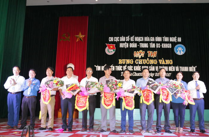 Lãnh đạo huyện Thanh Chương tặng cờ cho các đơn vị tham gia cuộc thi Rung chuông vàng. Ảnh: Mỹ Hà