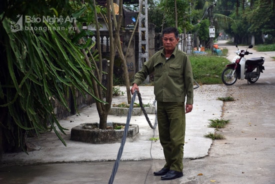 Ông Phan Văn Toán - Xóm trưởng xóm Xuân Lai, xã Đô Thành cho biết: Ảnh hưởng của cơn bão số 2, trên địa bàn xóm có nhiều cột điện bị gãy, gây điện vắt ngổn ngang trên đường, hàng rào. Xóm đã viết đơn đề nghị xã, huyện và ngành điện khắc phục nhưng đến nay đã sau 3tháng mà ngành điện vẫn chưa khắc phục xong, khiến người dân lo lắng bị điện dật, nhất là bọn trẻ con hàng ngày chơi ngoài đường. Trong ảnh: Ông Phan Văn Toán cầm bó dây điện bọc nằm trên đường làng từ nhiều tháng qua, do cột điện bị gãy. Ảnh: Xuân Hoàng