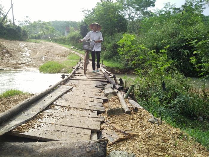 Nhiều năm qua mọi giao thương, đi lại của gần 100 hộ dân, 402 nhân khẩu ở thôn 17 xã Đức Sơn chỉ nhờ vào chiếc cầu tạm bắc qua khe Vệ De. Ảnh: Thái Hiền 