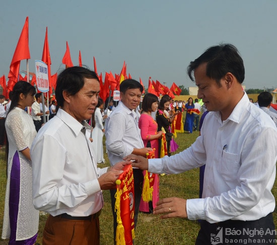 Lãnh đạo huyện Diễn Châu trao cờ lưu niệm cho các đoàn tham dự đại hội. Ảnh: Thu Hương