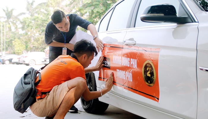 Để chuẩn bị cho cuộc diễu hành, các thành viên của diễn đàn đã rất công phu in băng rôn, dán hai bên và trước xe. Ảnh: Sách Nguyễn.