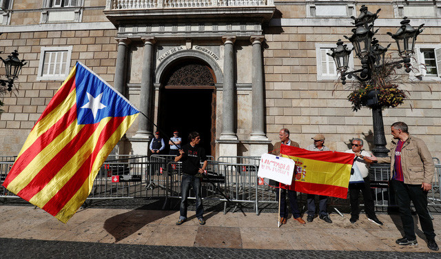 Người ủng hộ ly khai vẫy cờ Catalan (trái) và người ủng hộ thống nhất giương cờ Tây Ban Nha trước trụ sở chính quyền ở Barcelona ngày 30/10. Ảnh: Reuters