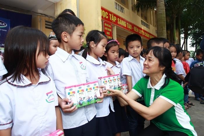 Bà Nguyễn Minh Tâm – Giám đốc Chi nhánh Vinamilk tại Hà Nội trao quà cho các em học sinh