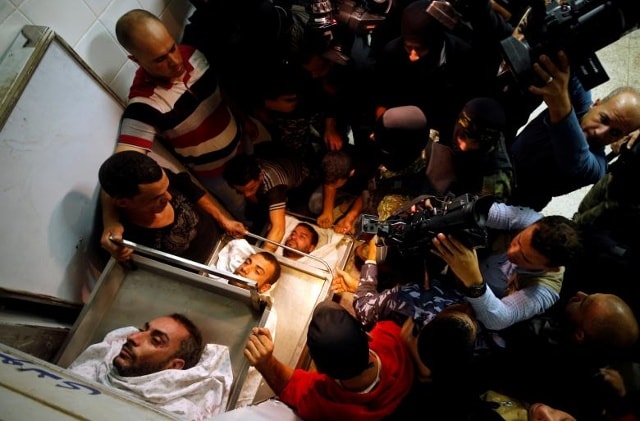 Mọi người tụ họp quanh các xác người Palestine bị giết trong một đường hầm gần biên giới giữa Israel và dải Gaza trung tâm.