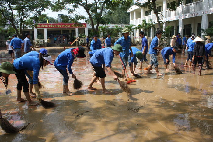 Sinh viên tình nguyện nhà trường giúp đỡ Trường Tiểu học Phạm Hồng Thái (Hưng Nguyên) dọn dẹp vệ sinh sau lũ lụt.