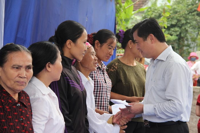 Đồng chí Thái Thanh Quý trao quà hỗ trợ cho các hộ nghèo xóm Chu Trạc. Ảnh: Hoài Thu