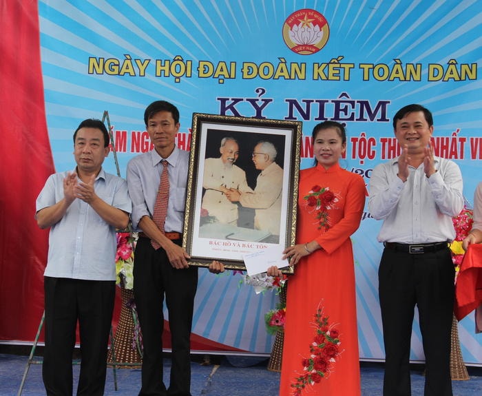 Trưởng Ban Dân vận Tỉnh ủy và lãnh đạo huyện Yên Thành trao tặng xóm Chu Trạc bức tranh Bác Hồ và Bác Tôn. Ảnh; Hoài Thu