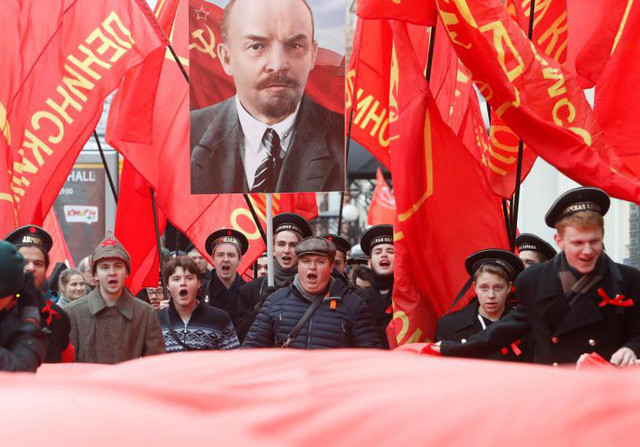 Trong ảnh: Dòng người mang những lá cờ đỏ và chân dung của cố lãnh tụ Lenin diễu hành kỉ niệm tại Matxcơva.
