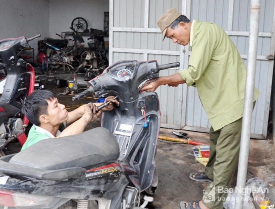 Đôi chân không thể đứng lên nên trong quá trình sửa chữa xe máy, anh Cao Cự Hùng