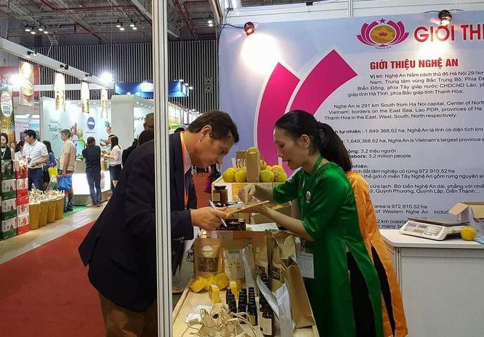 Du khách thích thú với sản phẩm Cam Vinh của Nghệ An. Ảnh: Vương Bằng