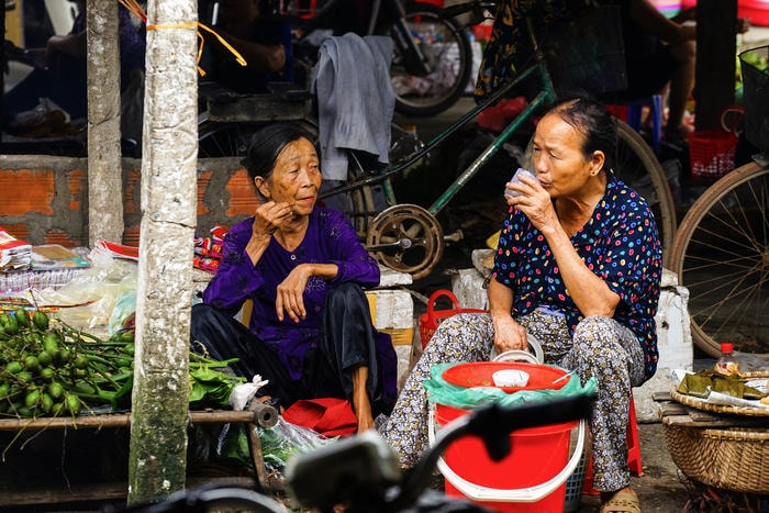 Những cuộc chuyện trò về làng trên xóm dưới của những bà bán hàng trong phút rỗi khách. Ảnh: Trung Hà