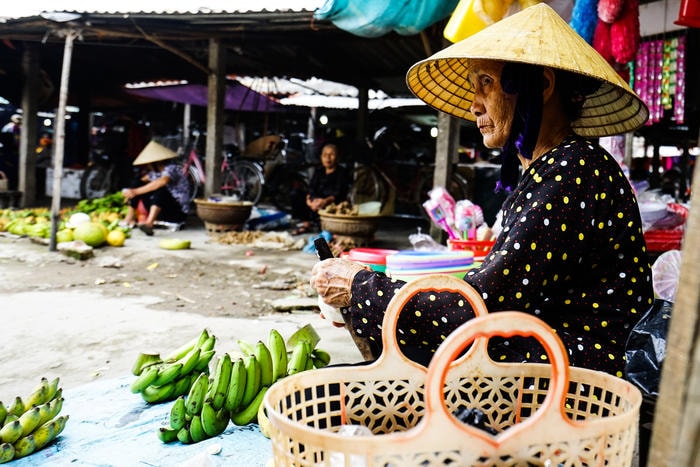 Xúc động với hình ảnh bà mẹ nghèo ngồi bên mép chợ với thức quà quê hái tự vườn nhà. Ảnh: Trung Hà