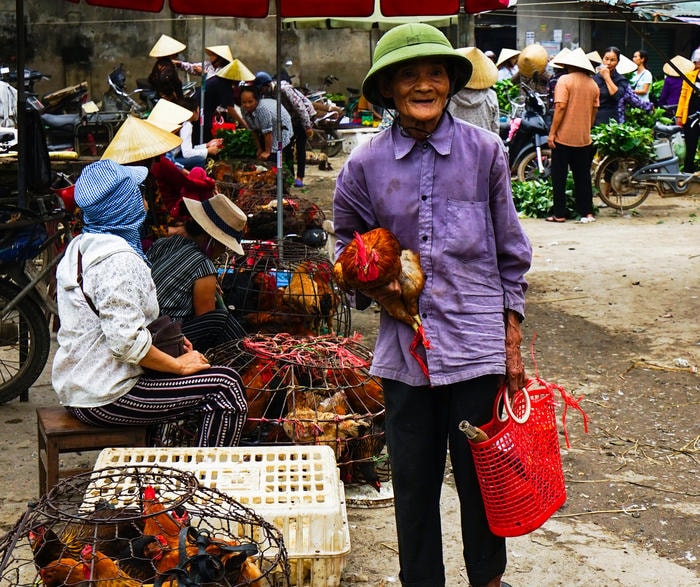 Một ông lão hài lòng với chú gà trống vừa mua được. Ảnh: Trung Hà