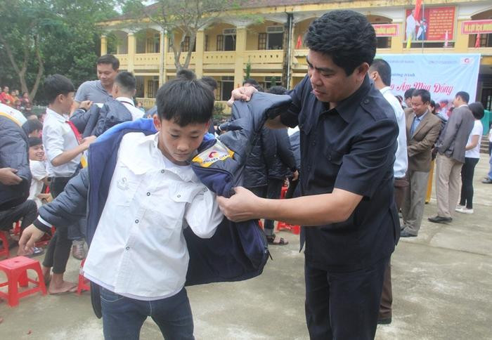 Ông Vi Văn Sơn, Chủ tịch UBND huyện Con Cuong trao áo ấm cho các em học sinh. Ảnh: Xuân Hòa