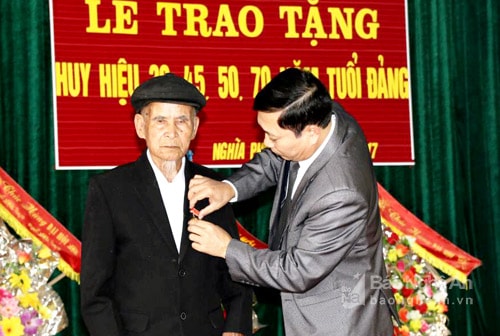 Đồng chí Phan Văn Giáp - Phó bí thư Huyện ủy Tân Kỳ trao huy hiệu 70 năm tuổi đảng cho đồng chí Nguyễn Thiện Viện