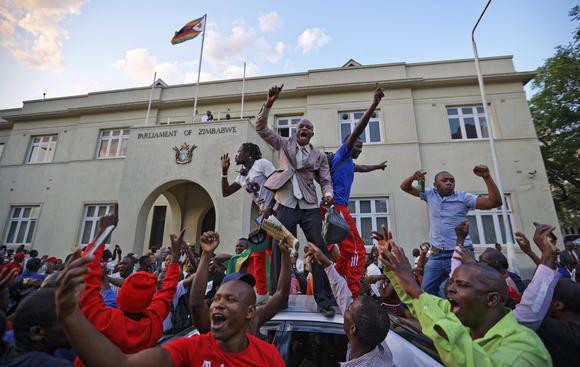 Người dân Zimbabwe hò reo trước tòa nhà Quốc hội sau khi Tổng thống Mugabe từ chức. Ảnh: AP