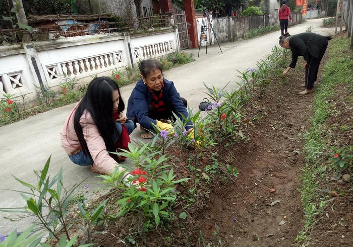 Người dân xã Nam Lĩnh (Nam Đàn) tham gia trồng, chăm sóc cho các đoạn đường hoa. Ảnh: Thúy Tình