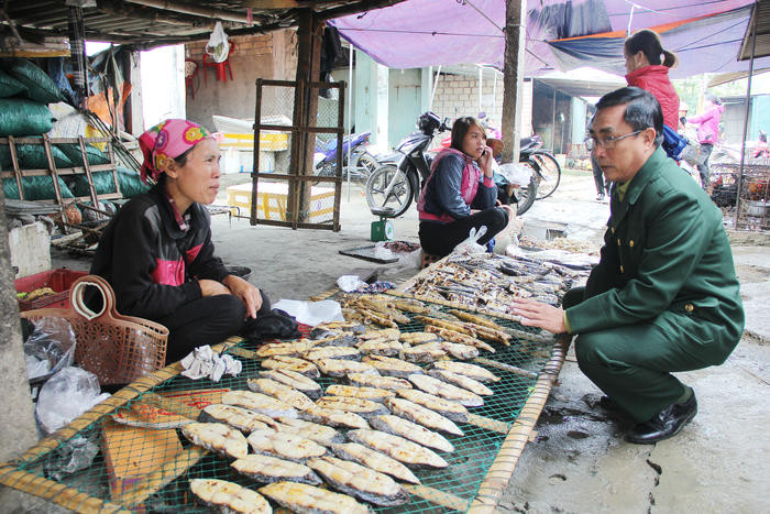 Ông Hồ Ngọc Hòa - Bí thư Chi bộ khối Ái Quốc, phường Quỳnh Phương (TX. Hoàng Mai) tìm hiểu tình hình kinh doanh tại chợ Càn. Ảnh: Mỹ Nga