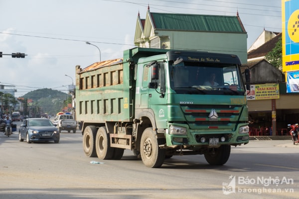 Chiều ngày chủ nhật 18/11, hàng loạt xe tải cơi nới chở đất rầm rậm lưu thông trên  tuyến quốc lộ 46 đoạn qua thị trấn Nam Đàn. Ảnh chụp lúc 15h22 cùng ngày tại ngã tư chợ Sa Nam.