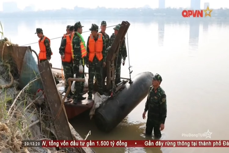 Hình ảnh lực lượng công binh thuộc Binh chủng Công binh trục vớt thành công quả bom dưới chân cầu Long Biên lên đất liền, còn ngòi nổ của nó bước đầu đã được vô hiệu quả. Nguồn ảnh: QPVN.