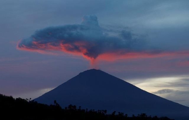 Một đám khói trên núi lửa Agung được chiếu sáng vào lúc mặt trời lặn khi thấy từ Amed, Karangasem Regency, Đảo Bali, Indonesia, ngày 30 tháng 11 năm 2017. 