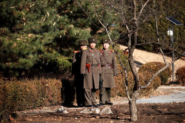 Những người lính Bắc Triều Tiên đang theo dõi về phía Nam, bên cạnh một điểm mà một người Triều Tiên đào thoát, vượt qua biên giới vào ngày 13 tháng Mười Một, tại làng trấn giữ Panmunjom bên trong khu phi quân sự, Nam Triều Tiên, ngày 27 tháng 11 năm 2017