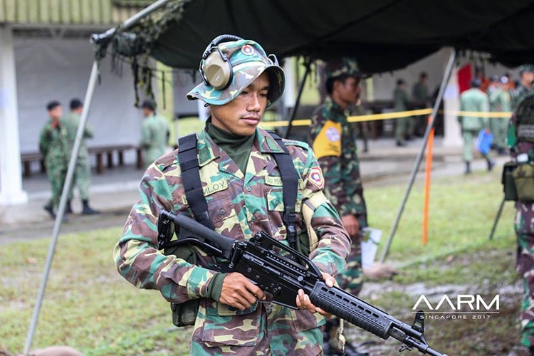 Và tại AARM năm nay, đội tuyển Lào tiếp tục sử dụng mẫu súng trường tấn công Pindad SS2-V1 mẫu súng gắn bó với các xạ thủ Lào trong các lần tham dự AARM gần đây. Vậy những khẩu SS2-V1 của Lào có nguồn gốc từ đâu?. Trong ảnh là một xạ thủ Lào với khẩu SS2-V1 tại AARM 2017. Nguồn ảnh: AARM.