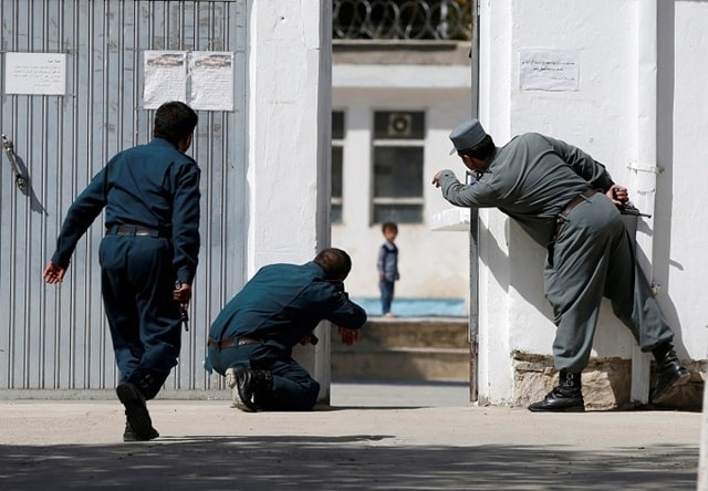 Cảnh sát Afghanistan đang tìm cách giải cứu một em nhỏ tại khu vực xảy ra các cuộc đụng độ giữa lực lượng Afghanistan và phiến quân sau vụ tấn công nhằm vào một nhà thờ ở thủ đô Kabul hôm 25/8. Ảnh: Reuters.