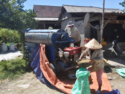 Bà con người Thái ở khu tái định cư xã Ngọc Lâm (Thanh Chương) tuốt lúa bằng máy tuốt liên hoàn. Ảnh: Công Kiên