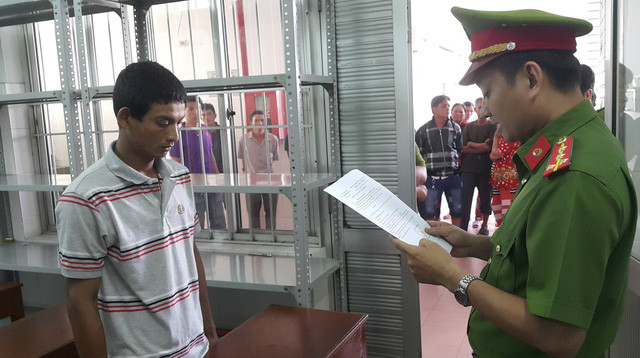 Cơ quan công an tống đạt quyết định khởi tố và bắt tạm giam Nguyễn Nhâm Thiện.  Ảnh: Huy Phách