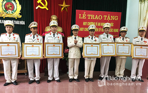 Thừa ủy quyền, Trung tá Trần Ngọc Tuấn, Trưởng công an thị xã Thái Hòa trao Huy chương Chiến sĩ vẻ vang cho các đồng chí đang công tác tại công an thị xã Thái Hòa. Ảnh: Hoàng Long