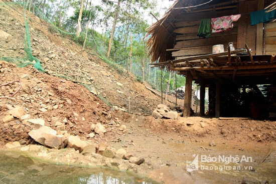 Những ngôi nhà nằm bên suối cũng bị đất đá tràn vào nguy cơ phải di dời sớm. Ảnh: Minh Khuê